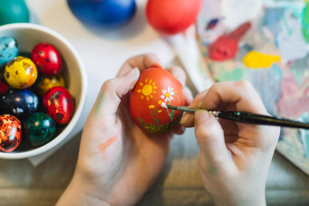 Close up of girl's hands painting on Easter egg