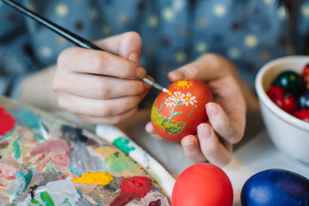 Close up of girl's hands painting on Easter egg
