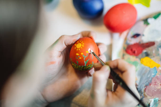 istock Young girl painting on Easter egg 1211606163