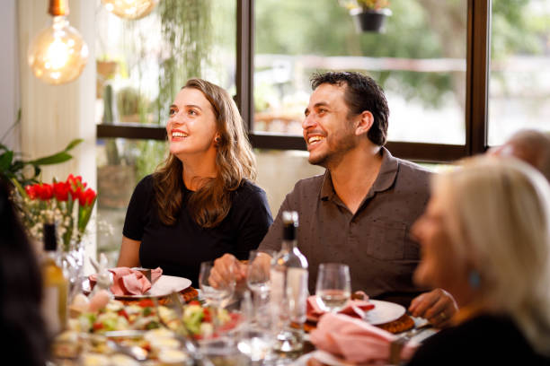 couple sitting at the table on family lunch - flower arrangement dining room decor dining imagens e fotografias de stock