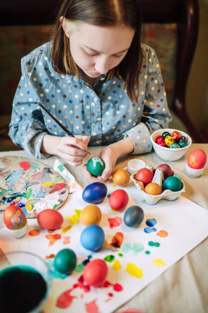 istock Young girl painting on Easter egg 1211606409