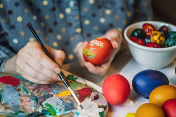 istock Young girl painting on Easter egg 1211606433