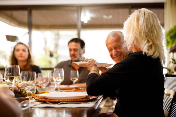 istock Senior woman serving others on table 1211606473