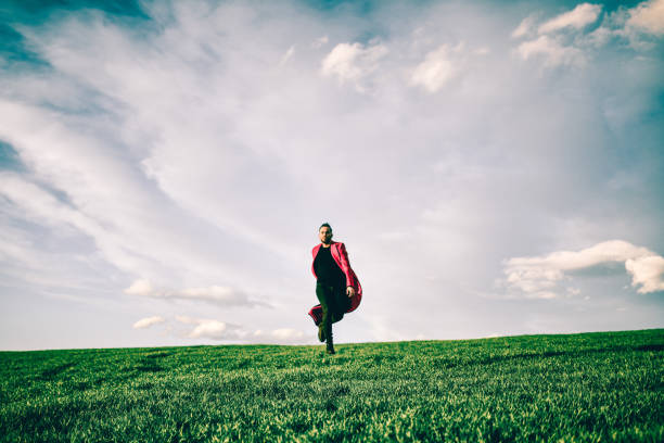 Female figure in black jacket and red scarf, stands outdoors surrounded by trees, embracing the fresh air and nature, radiating happiness and tranquility