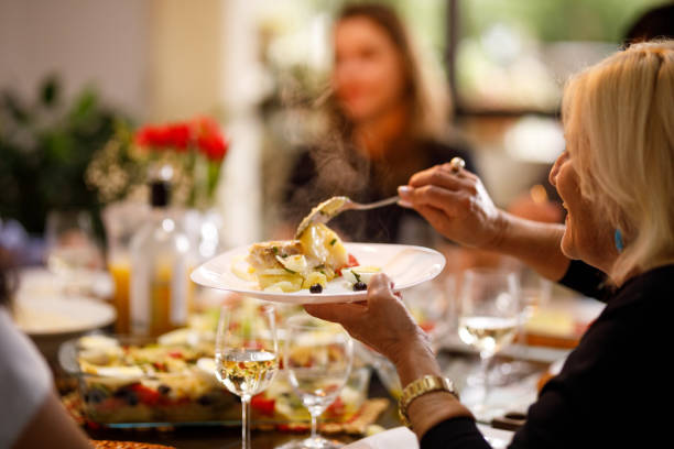 donna anziana che serve cibo caldo fresco a pasqua - cod foto e immagini stock