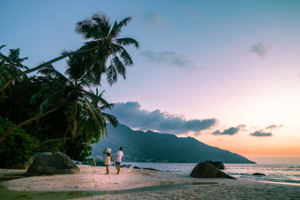 istock couple walking on tropical beach Mahe Seychelles during sunset 1211606765