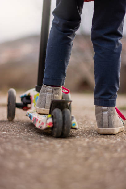 istock Little girl's legs with scooter 1211607753