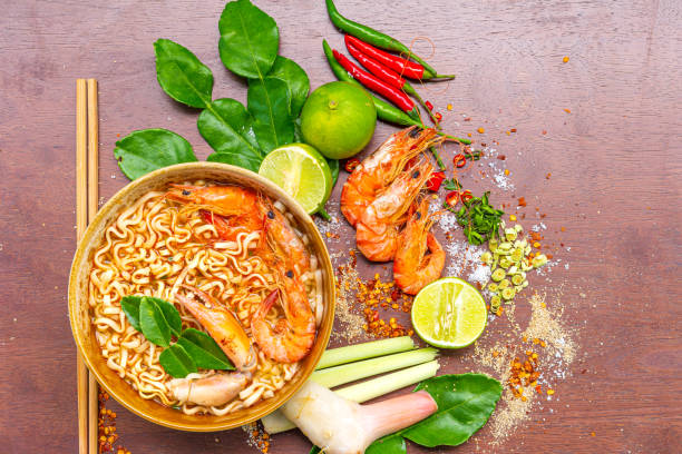 instant noodles shrimp tom yum flavor,instant noodles shrimp tom yum flavor es la comida tailandesa más popular, servida en cuenco de madera y colocar en la mesa - tom tom yum meal soup fotografías e imágenes de stock