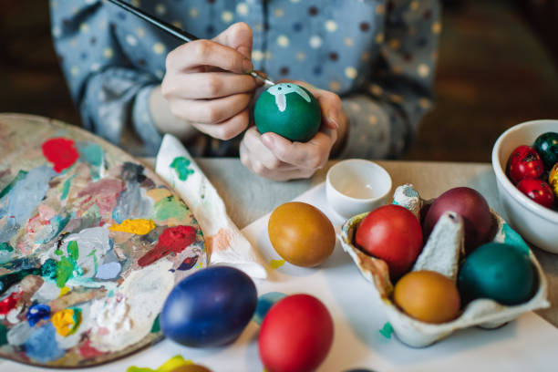 istock Young girl painting on Easter egg 1211609426