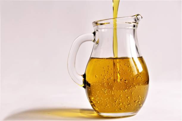 pouring olive oil to the glass jar photo - olive oil pouring antioxidant liquid imagens e fotografias de stock