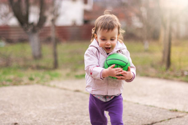 istock Child playing with a ball in the yard 1211610524