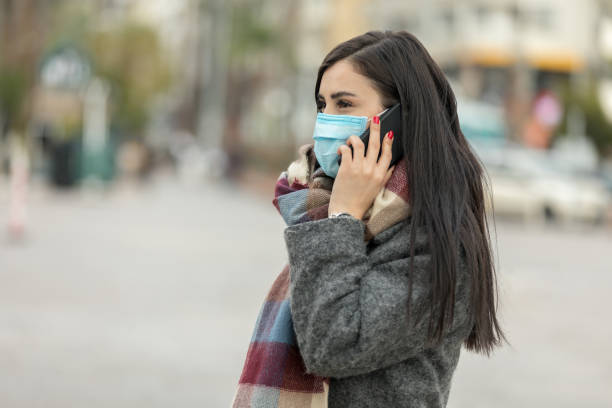 istock Woman with mask talking on the phone. 1211613533