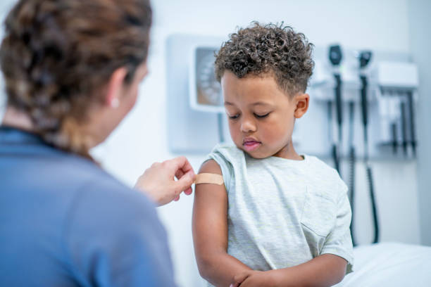 doctor putting bandage auf little boy stockfoto - grippeimpfstoff stock-fotos und bilder