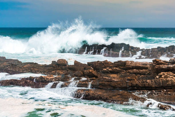 Waves crashing wildly on the rocky shore at Storms River Mouth, Tsitsikamma National Park, the Garden Route, South Africa