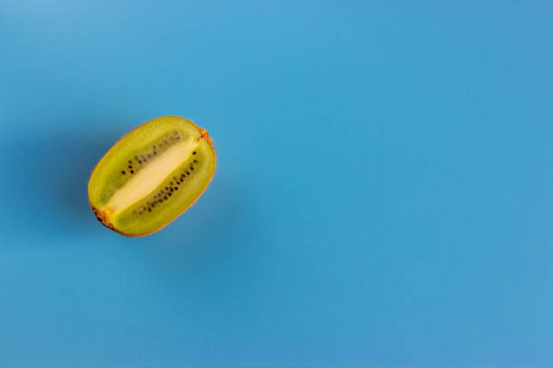 istock Kiwi fruit cut into slices on a blue background.  Exotic healthy fruit. Copy space for text 1211615100