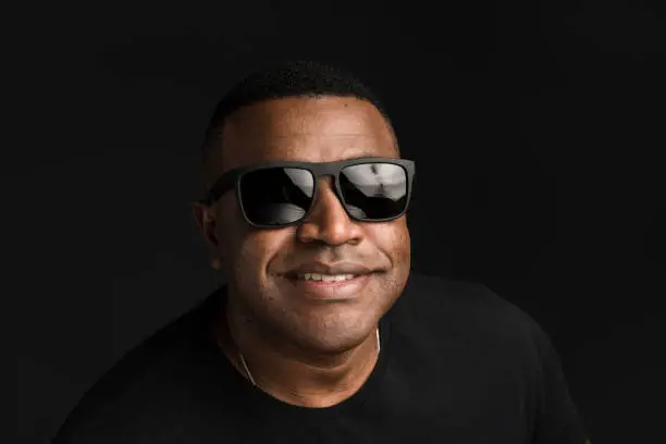 Head shot, one man, afro, smiling, sunglasses, looking at camera