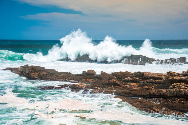 Waves crashing wildly on the rocky shore at Storms River Mouth, Tsitsikamma National Park, South Africa