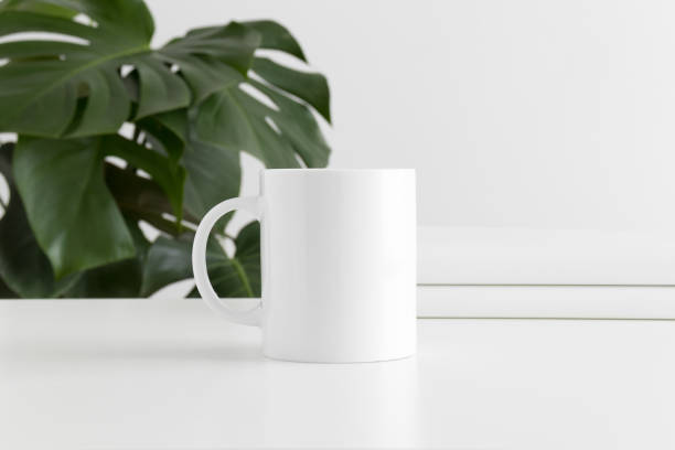 istock Mug mockup with workspace accessories and a monstera plant. 1211616445