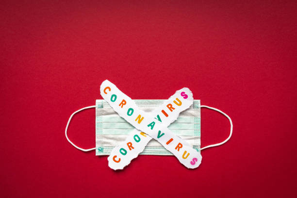 istock Word Coronavirus on protective face mask and thermometer on red background. Covid-19 1211616656
