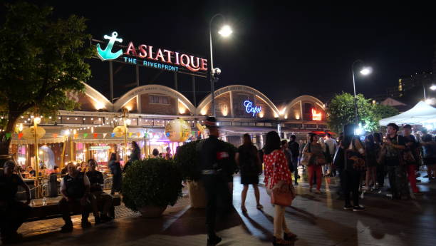 Bangkok, Thailand-November 10, 2019: Outdoor tables at restaurant at Asiatique, Bangkok. People dinning at the tables. Some people walk past the restaurant.