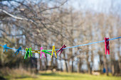 Colorful plastic clothes pegs on white clothesline, fashion business concept