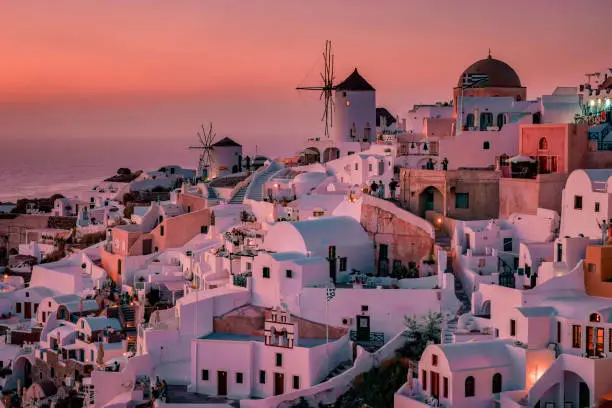 Photo of Santorini Oia village during sunset whit luxury hotels and whitewashed buildings in Santorini Island a luxury vacation destination in Greece