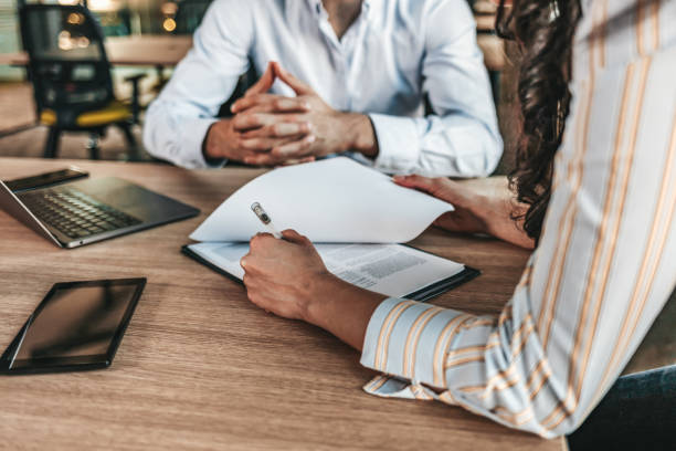 Business people negotiating a contract Female businessperson signs contract. Close up of female hand signing formal paper on the office table witness stock pictures, royalty-free photos & images