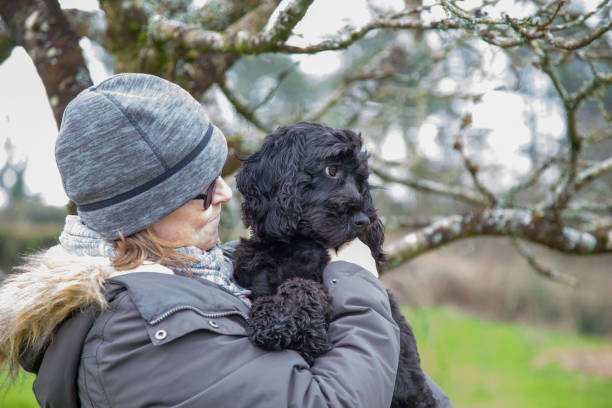 istock mature woman with cute black dog 1211622480