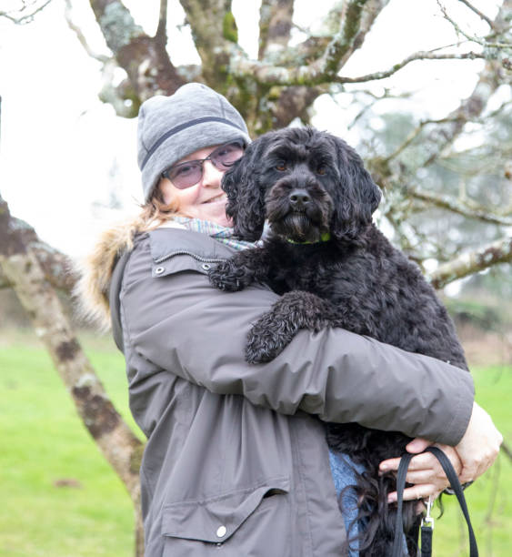istock mature woman with cute black dog 1211622631