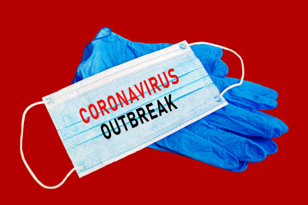 istock Surgical protective mask and medical gloves with the text CORONAVIRUS OUTBREAK on white background. 1211623899