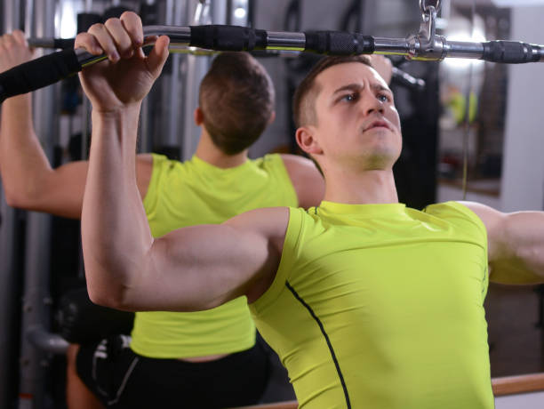 istock Handsome young man doing strength workout exercise in gym 1211625238