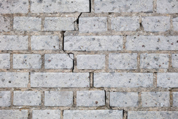 cracked wall of white bricks cracked wall of white bricks construction material torn run down concrete stock pictures, royalty-free photos & images