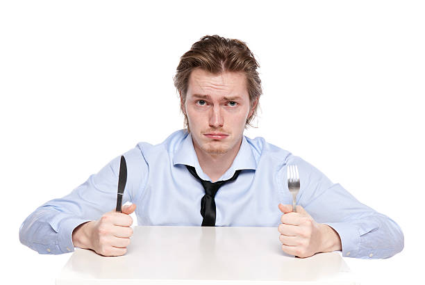 istock Young man holding fork and knife with a hungry expression 121162589