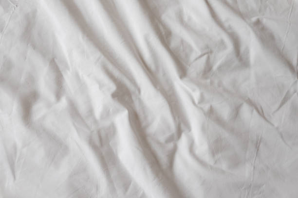 istock Background of white rumpled sheets. Bed linen with wrinkles in day light. Horizontal. Copy spase. Concept of rest, awakening, sleep. For social media, blog 1211626319