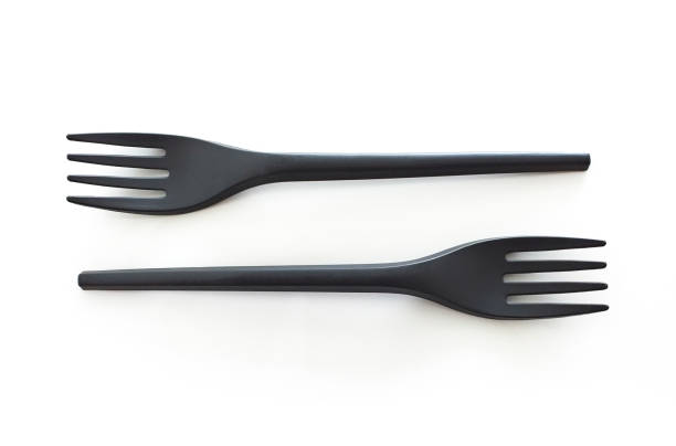 istock Close up of two disposable black plastic forks on white background. Horizontal view. Save earth concept. 1211627424