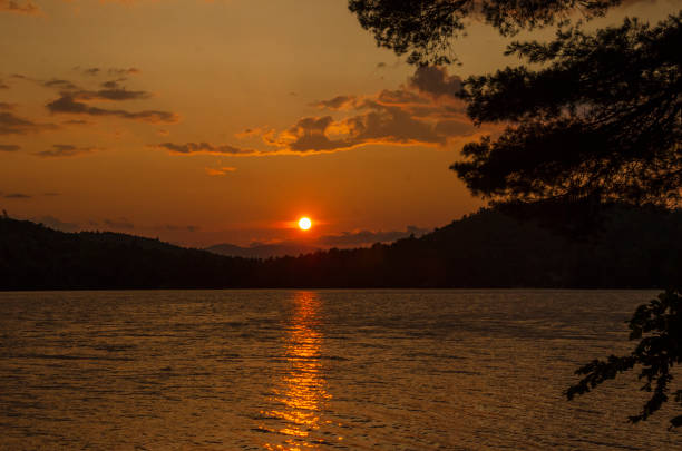 A view of sunset over a lake in central Maine in the summer.