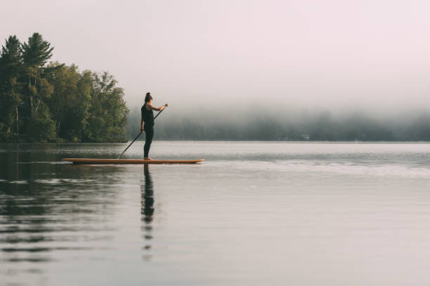 istock Young Woman Paddleboarding On A Calm Lake 1211628859