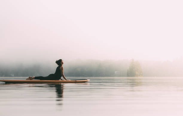 Young Woman Practicing Yoga On A Paddleboard stock photo