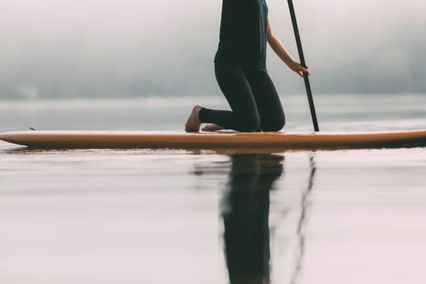 istock Young Woman Paddleboarding On A Calm Lake 1211628905
