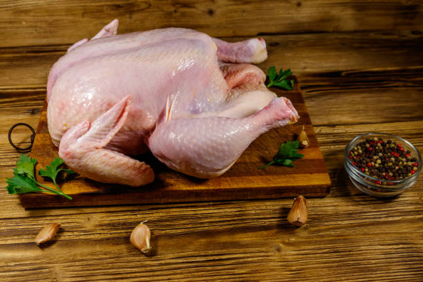 istock Raw whole chicken with spices on a wooden table 1211629249