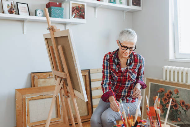 istock Mature Woman Painting 1211629310