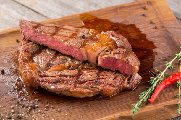 istock Cut Rib eye steak on wooden board, closeup 1211631310