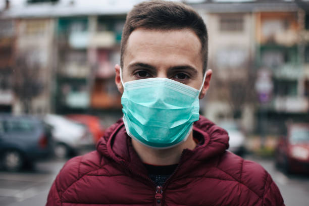 homens na cidade usando máscara facial protetora - smog city pollution town - fotografias e filmes do acervo