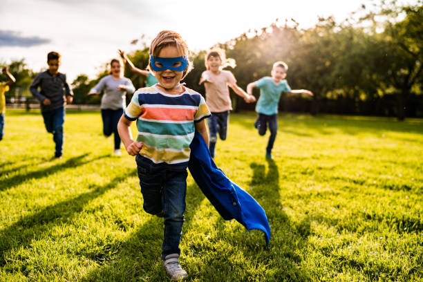 子供たちから走っている小さなかわいい男の子 - partnership creativity superhero child ストックフォトと画像