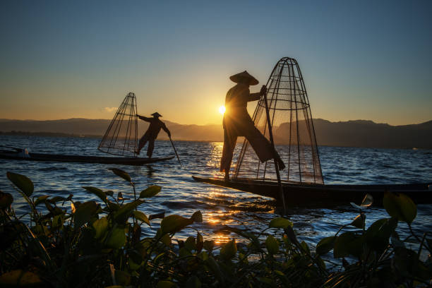 Myanmar, Shan state, Inle lake Intha fisherman on boat at amazing sunset stock photo