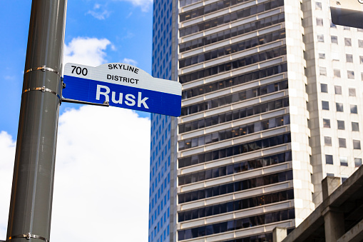 Rusk street sign in downtown Houston, Texas with skyscrapers in the background.