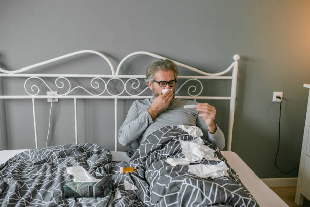 istock Mature man laying sick in bed 1211634404
