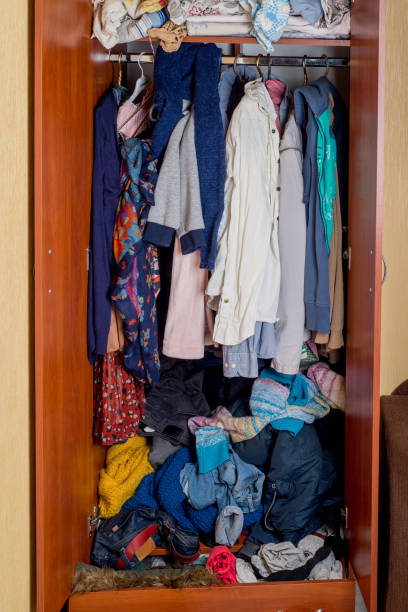 istock open wardrobe with clothes on hangers and clutter in open drawers 1211634540