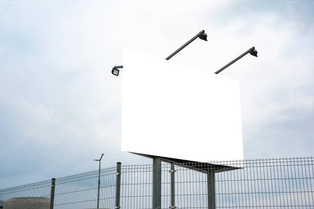 istock Blank white billboard mockup against cloudy sky 1211640303