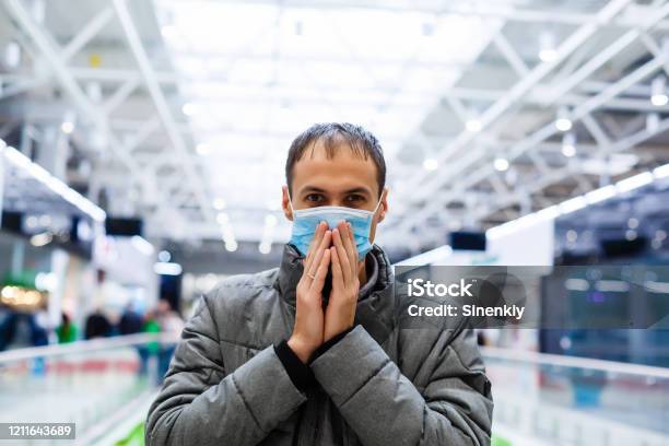 A Young Man In A Medical Mask In A Shopping Center The Masked Man Protects Himself From The Epidemic Of The Chinese Virus 2019nkov Stock Photo - Download Image Now